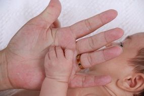 Hand of baby on adult personâs palm