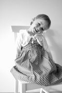girl in a dress on a white chair