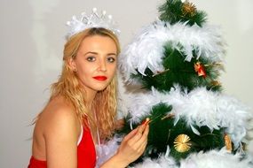 crowned blonde girl with red lips near Christmas tree