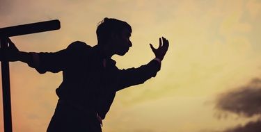 dark silhouette of a young man at dusk