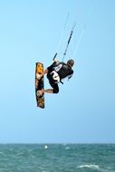 A surfer on a board jumps over the water