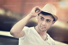 young man posing with a hat