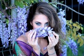 woman sniffing violet flowers