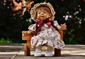 beautiful doll on a wooden bench