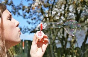 Portrait of Girl blows Soap Bubbles