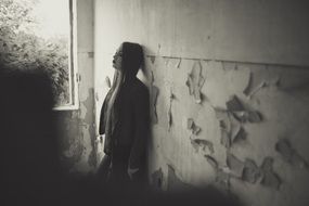 Black and white photo of the girl near the wall