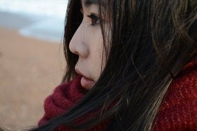 Asian girl standing at the cold sea