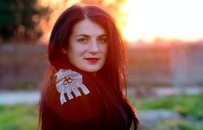 portrait of a girl in black clothes on a sunset background