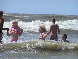 caucasian Children playing in Sea waves
