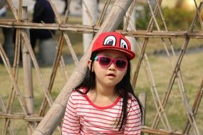 child in a red cap and sunglasses