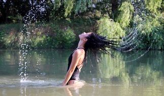 brunette girl tossing her hair in water