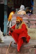 elderly man in red clothes outdoors in india