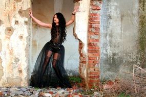 girl in a black transparent dress among the ruins