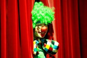 clown in a green wig behind the red backstage