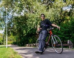 man waits near a bicycle in the park