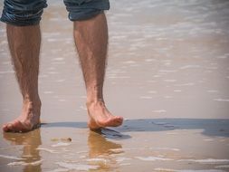 men's feet on the beach
