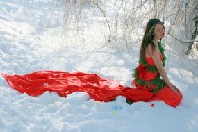 girl in a long red dress in the snow
