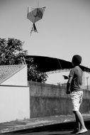 child with a kite in black and white image