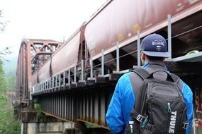 man stands at the railway bridge