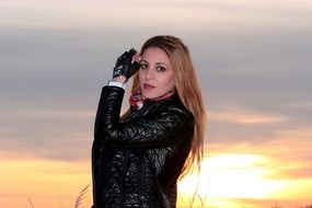 portrait of a girl in a black suit on a sunset background