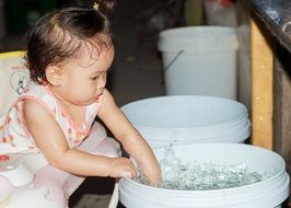 Baby Splashing in the water in plastic buckets