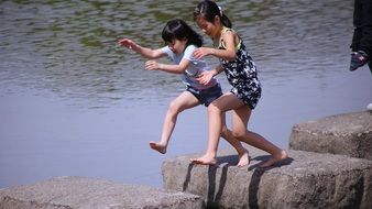 children jump on stone slabs