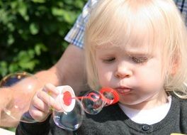 young girl making soap bubbles