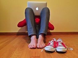 young person with laptop on the floor