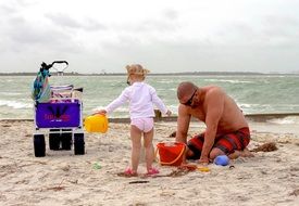 dad with a child on a sandy beach