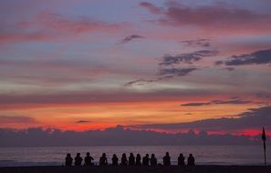 people on the beach watching the sunset