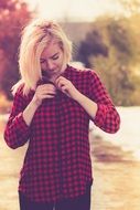 blonde in a plaid shirt among nature