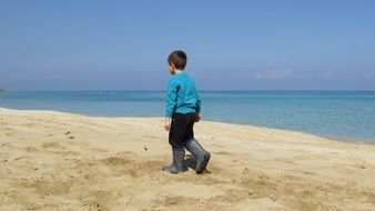 Kid walking on a sandy beach