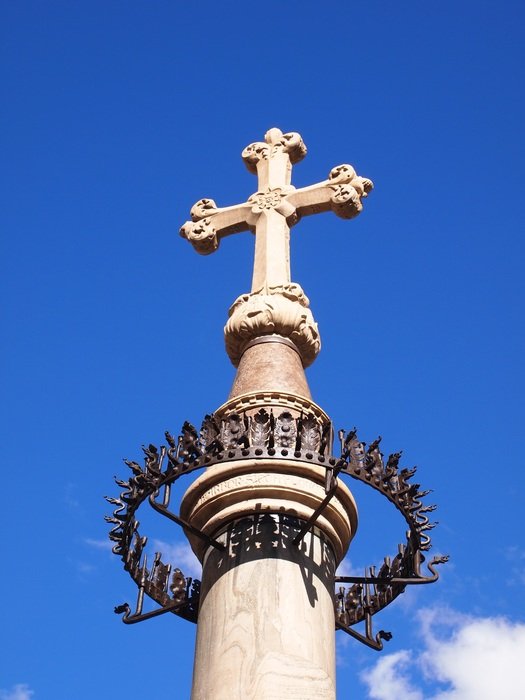 cross as a symbol of toscana on blue sky background with white clouds