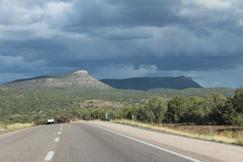 highway against mountains and stormy sky