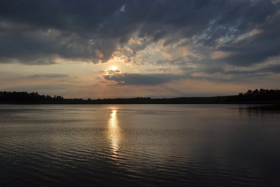 sunny path on the surface of the lake at sunset