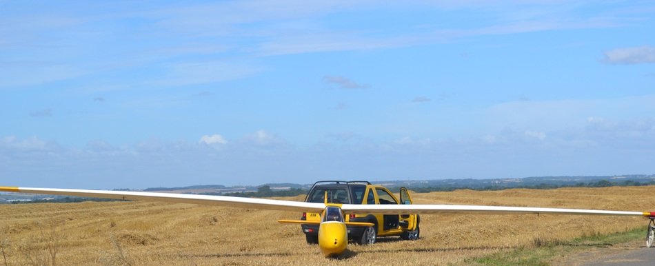 yellow jeep and yellow glider at the airfield