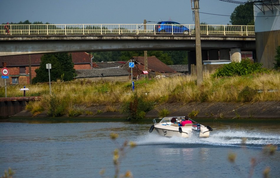 motor boat sailing under a bridge