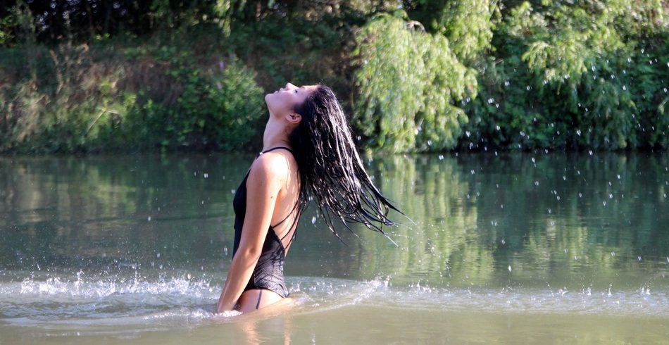 sensual brunette with long hair in spray of water