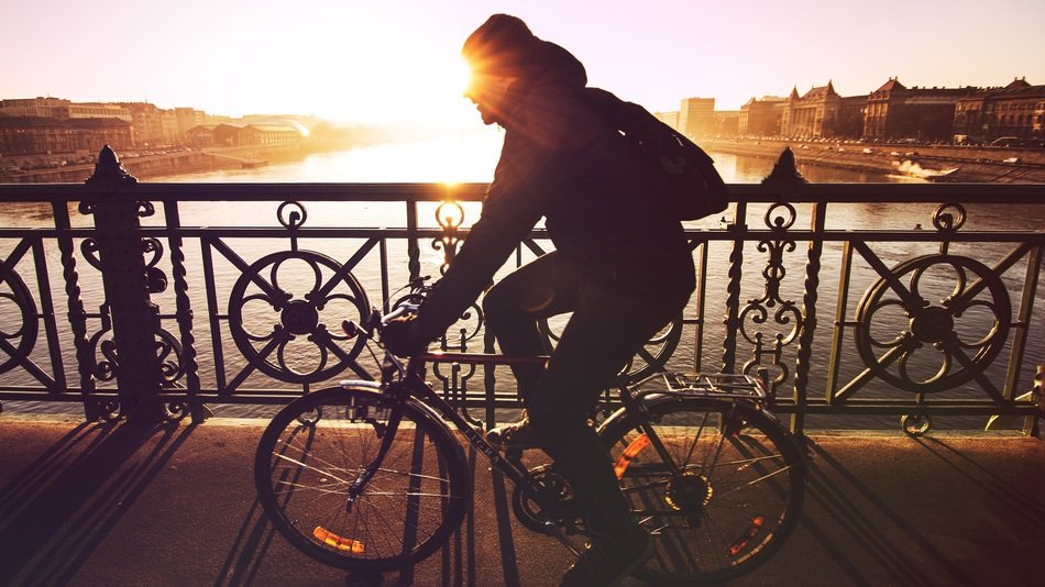 man cycling on sunset background