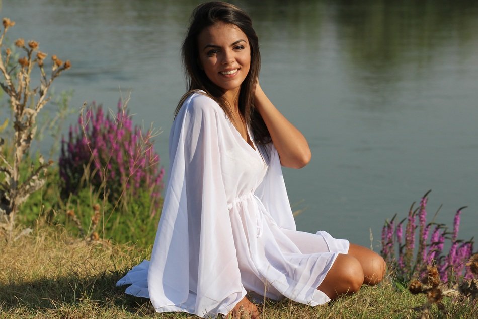 Photo of a girl in a white dress by the river