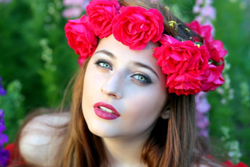 photo of a beautiful girl with a wreath of red roses on her head