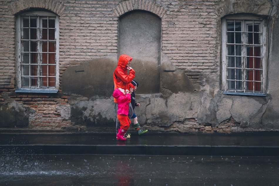 family in red raincoats in the rain