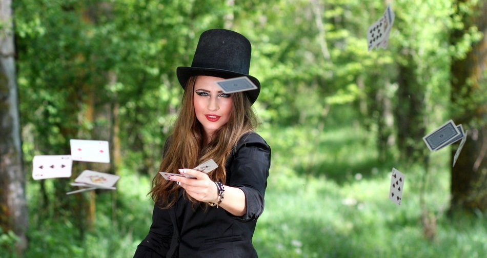 woman in topper throwing playing cards