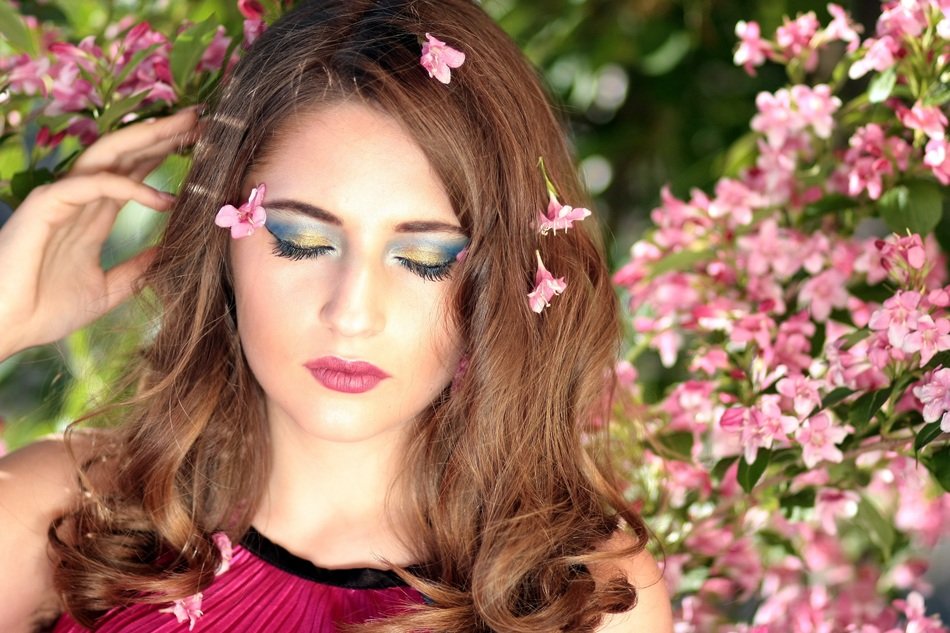 girl with closed eyes on a background of pink flowers