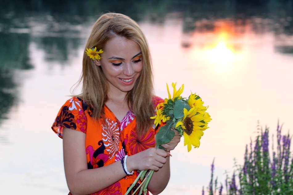 blonde with a bouquet of sunflowers near the water