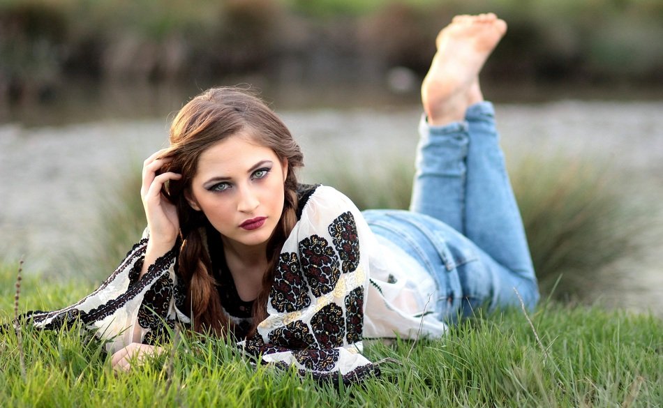 beautiful girl on the grass near the lake