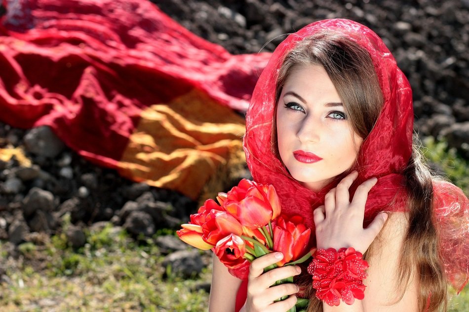 Portrait of beautiful woman with red tulips in hands