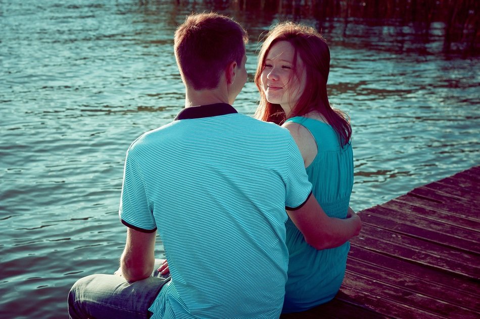 guy and girl on the shore of the pond