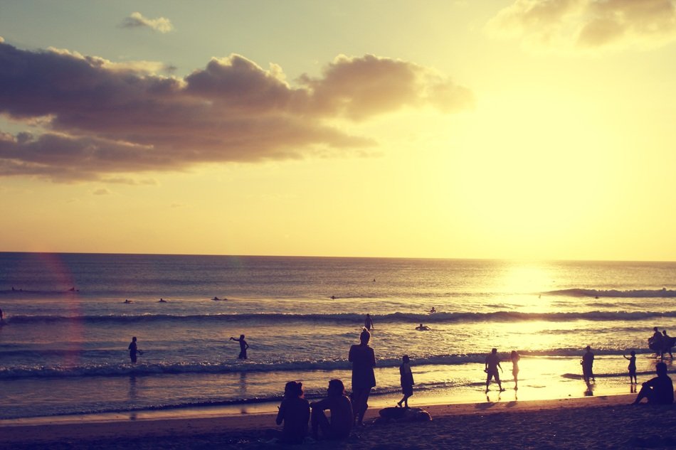 Colorful sunset and people on the beach in the summer