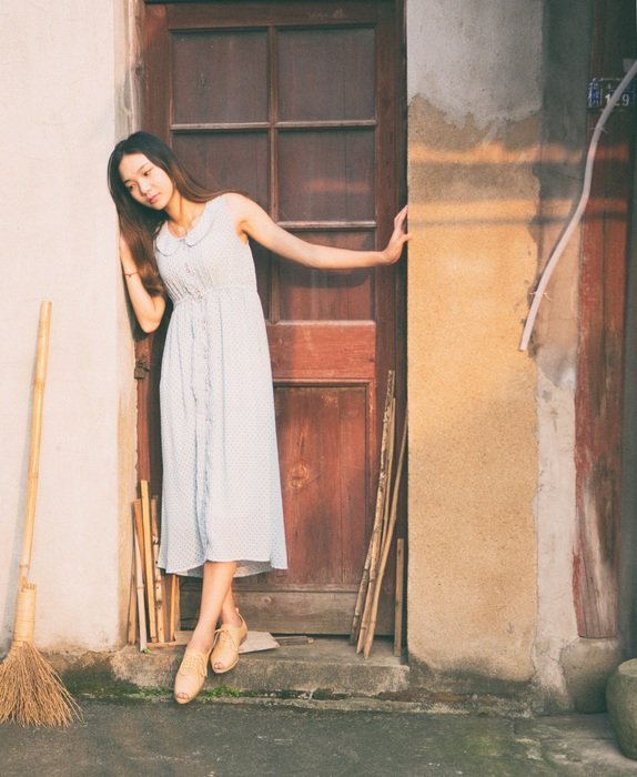 girl in a white dress near the wooden door